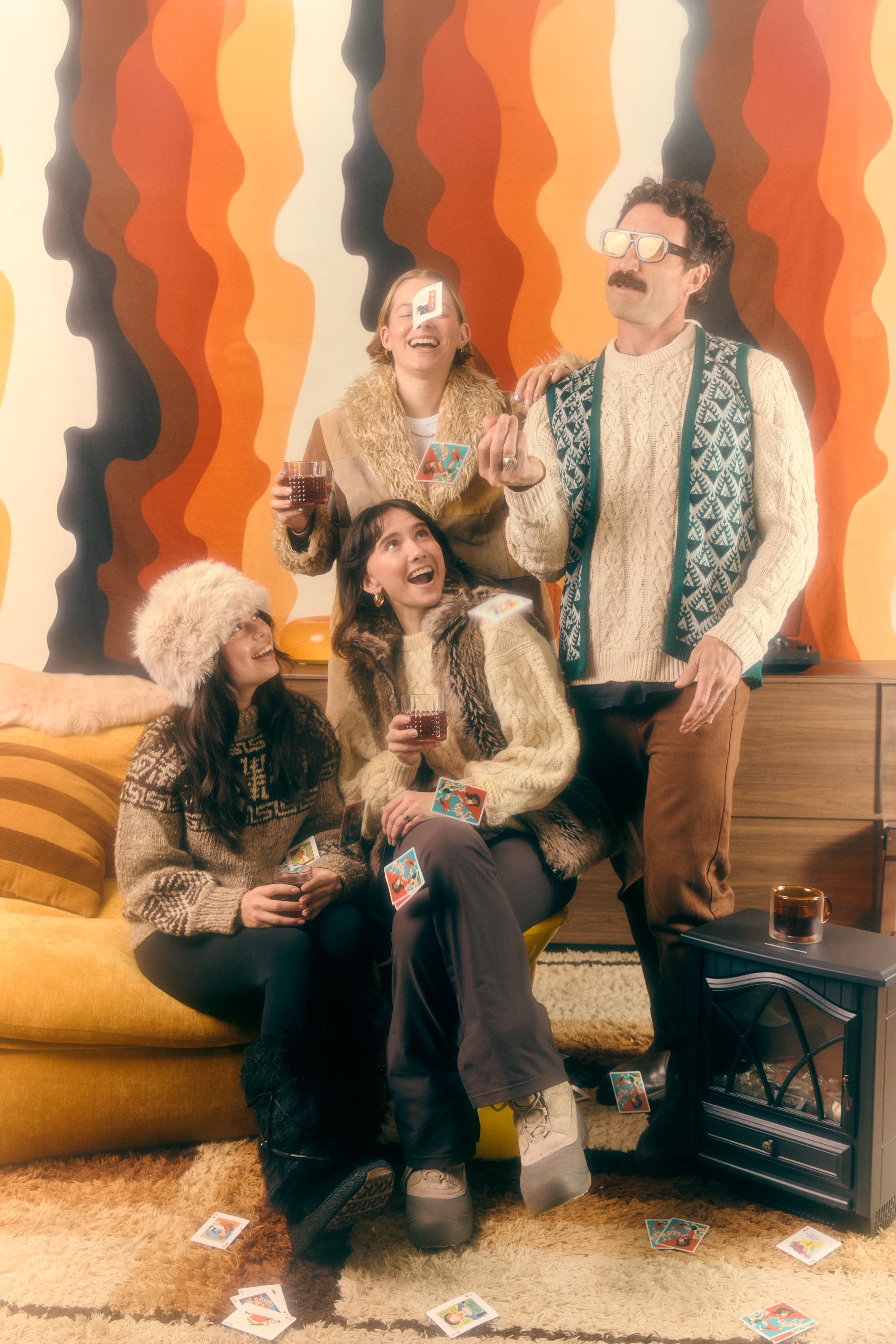 Limber crew laughing together in a retro lounge room, 70s wallpaper behind them